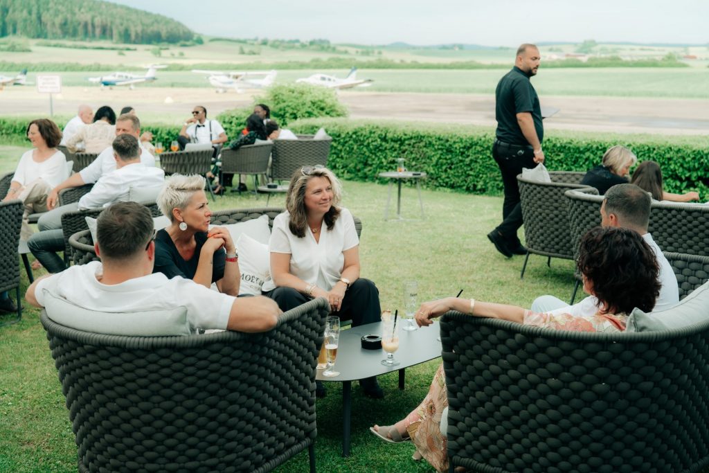 Hochzeitsgäste beim Sektempfang im Außenbereich des Sombea Donaueschingen mit Blick ins Grüne“