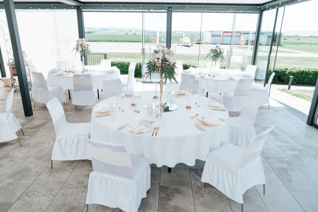 Überdachte Terrasse im Sombea Donaueschingen mit rund gedeckten Hochzeitstischen und Panoramablick
